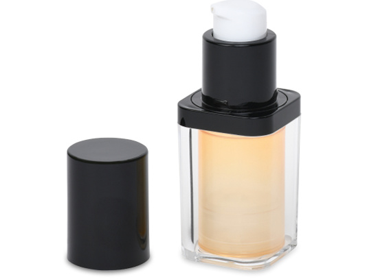A clear rectangular bottle with a black pump and cap dispenses a light-colored liquid. The cap is placed to the left of the bottle, revealing the pump mechanism. The bottle has a sleek, modern design suitable for cosmetics or skincare products.